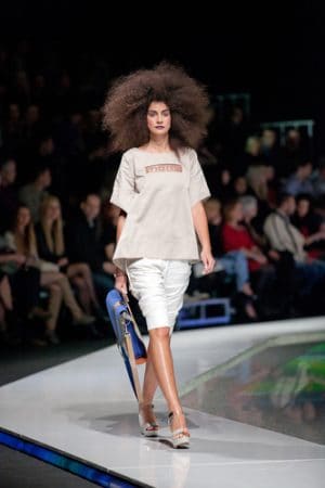 Runway model wearing a loose-fitting top with a pencil skirt.