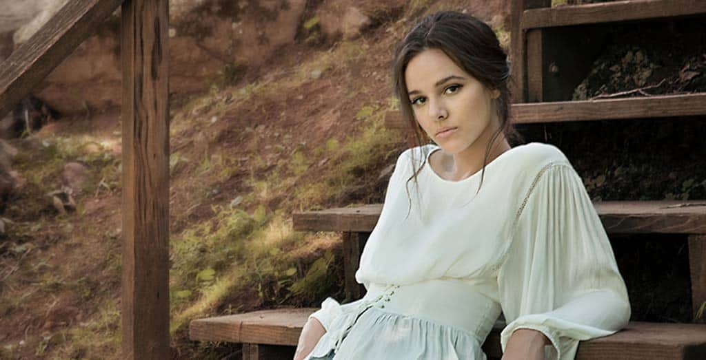 Brunette wearing white shirt with soft hairdo and neutral makeup