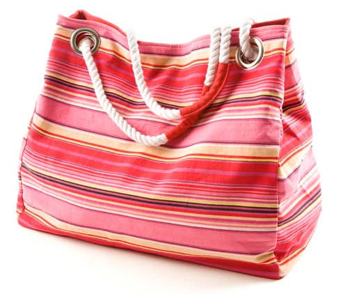 Pinkish canvas striped beach bag with rope shoulder strap isolated on white background.