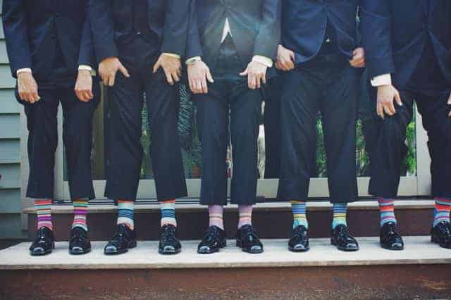 men in suits wearing colorful socks