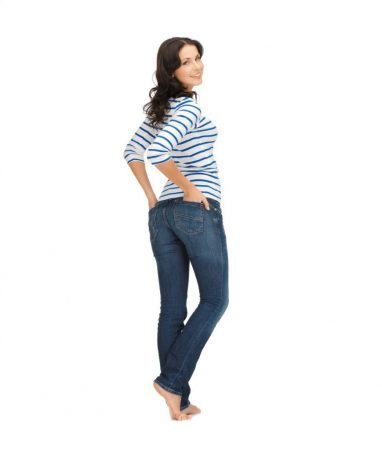 brunette wearing jeans against white backdrop