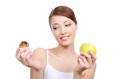 female choice - high-calorie cake or healthy apple - white background