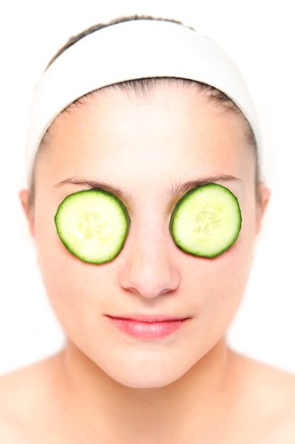 Woman with cucumber slices on her eyes