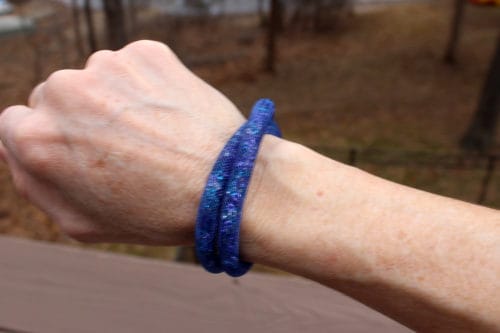 Wrist showing off a double-wrapped blue bracelet